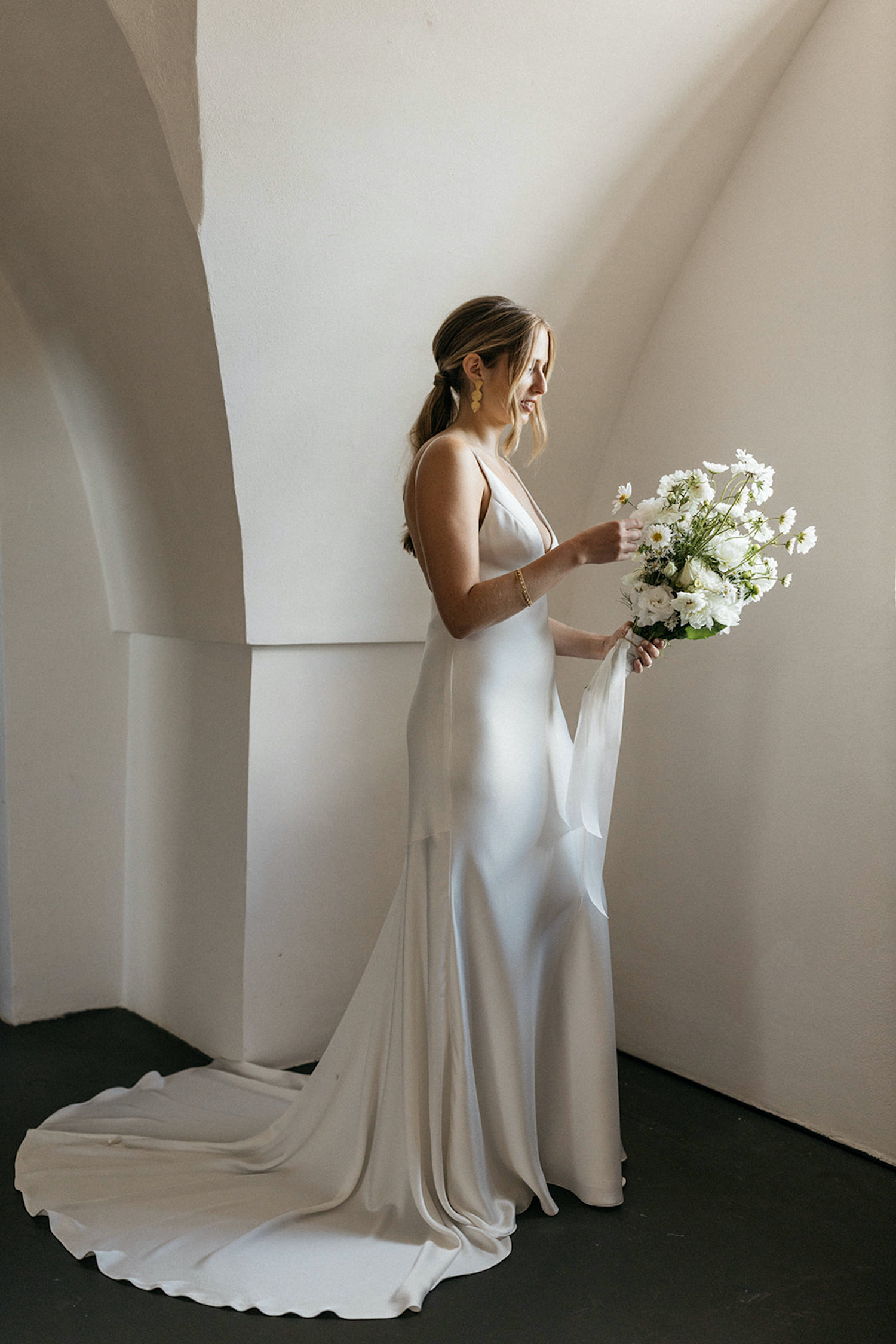 Bride looking at her white wedding bouquet at her Masseria Belvedere wedding